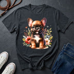 Black t-shirt with a dog graphic on a dark surface with shoes and jeans.