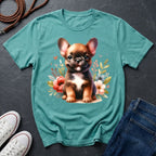 Teal t-shirt with a dog graphic on a dark surface with shoes and jeans.
