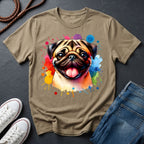 Beige t-shirt with a colorful pug design on a dark surface with shoes and jeans.