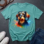 Teal t-shirt with a colorful dog graphic on a dark surface with shoes and jeans.