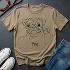 Beige t-shirt with a pug graphic and 'Pug' text on a dark surface with shoes and jeans.
