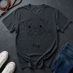 Dark gray t-shirt with a pug graphic and 'Pug' text on a dark surface with shoes and jeans.