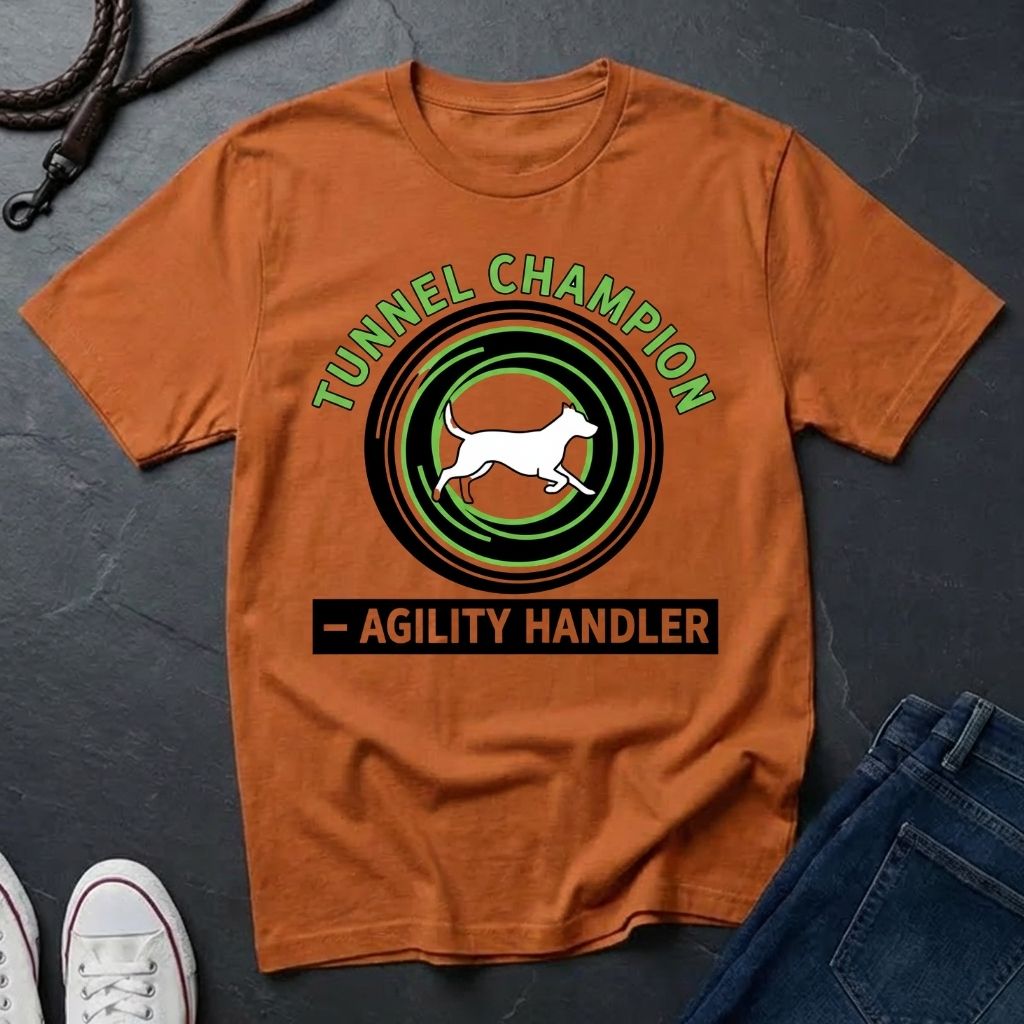 Beige t-shirt with 'Tunnel Champion Agility Handler' graphic on a dark surface with shoes and jeans.