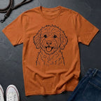 Orange Comfort Colors t-shirt with a dog illustration on a dark surface with jeans and shoes.