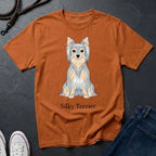 Orange Comfort Colors t-shirt with a silky terrier graphic and text on a dark surface.