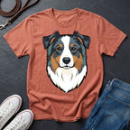 Brown Comfort Colors t-shirt with a dog graphic, white sneakers, and blue jeans on a dark surface
