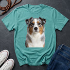 Teal Comfort Colors t-shirt with a dog graphic on a dark surface with shoes and jeans.