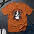 Orange Comfort Colors t-shirt with Bernese Mountain Dog graphic and text on a dark surface.