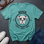 Teal Comfort Colors t-shirt with boxer dog graphic and text on a dark surface with shoes and jeans.