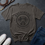 Gray Comfort Colors t-shirt with Australian Shepherd graphic and text on a dark surface with shoes and jeans.