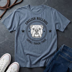 Blue Comfort Colors t-shirt with English Bulldog graphic and text on a dark surface with shoes and jeans.