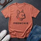 Coral Comfort Colors t-shirt with a dog illustration and 'FRENCHIE' text on a dark surface with shoes and jeans.