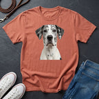 Orange Comfort Colors t-shirt with a dog graphic on a dark surface with shoes and jeans.