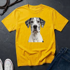 Yellow Comfort Colors t-shirt with a dog graphic on a dark surface with shoes and jeans.