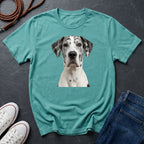 Teal Comfort Colors t-shirt with a dog graphic on a dark surface with shoes and jeans.