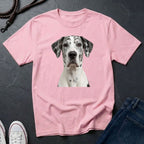Pink Comfort Colors t-shirt with a dog graphic on a dark surface with jeans and shoes.