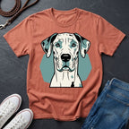 Coral Comfort Colors t-shirt with a dog graphic on a dark surface with shoes and jeans.