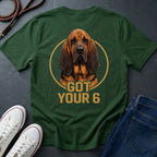 Green Comfort Colors t-shirt with a dog graphic and text 'Got Your 6' on a dark surface with shoes and jeans.