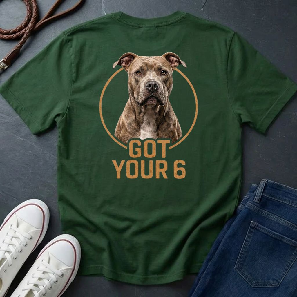 Green Comfort Colors t-shirt with a dog graphic and 'Got Your 6' text on a dark surface with shoes and jeans.