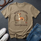 Beige Comfort Colors t-shirt with Italian Greyhound design on a dark surface with shoes and jeans.