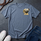 Blue Comfort Colors t-shirt with a dog graphic on a dark surface with shoes and jeans.