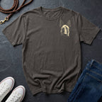 Gray Comfort Colors t-shirt with dog graphic, white sneakers, and blue jeans on a dark surface