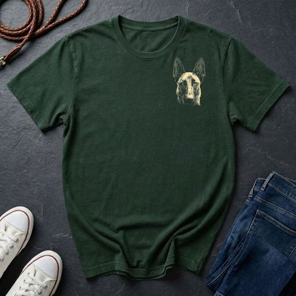 Green Comfort Colors t-shirt with a dog graphic on a dark surface with shoes and jeans.