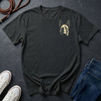 Black Comfort Colors t-shirt with a dog graphic on a dark surface with shoes and jeans.