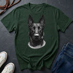 Green Comfort Colors t-shirt with a black and white dog illustration on a dark surface with shoes and jeans.