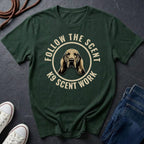Green Comfort Colors t-shirt with a dog graphic and text 'Follow the Scent K9 Scent Work' on a dark surface.