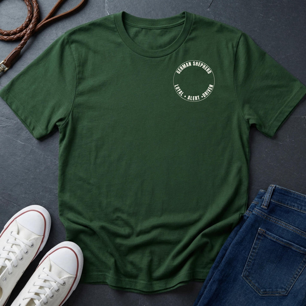 Green Comfort Colors t-shirt with a logo on a dark surface with shoes and jeans.