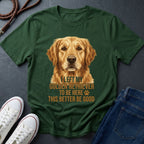 Green Comfort Colors t-shirt with a golden retriever graphic and text on a dark surface with shoes and jeans.