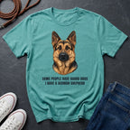 Teal Comfort Colors t-shirt with a German Shepherd graphic and text on a dark surface with shoes and jeans.