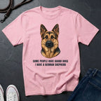 Pink Comfort Colors t-shirt with a German Shepherd graphic and text on a dark surface.