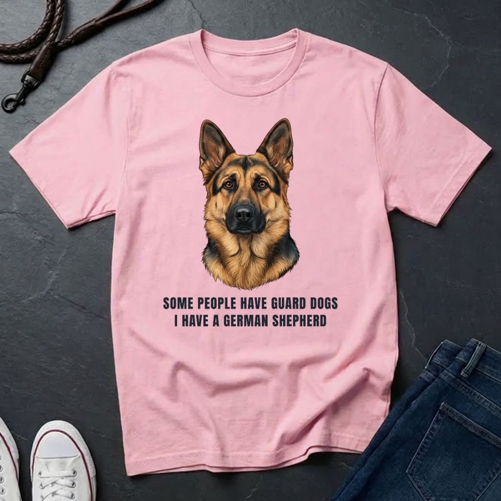 Pink Comfort Colors t-shirt with a German Shepherd graphic and text on a dark surface.