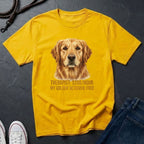 Yellow Comfort Colors t-shirt with a golden retriever graphic and text on a dark surface.
