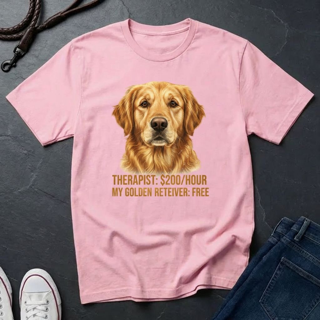 Pink Comfort Colors t-shirt with a golden retriever graphic and text on a dark surface.