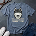 Blue Comfort Colors t-shirt with husky graphic and text on a dark surface with shoes and jeans.