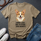 Beige Comfort Colors t-shirt with a corgi graphic and text on a dark surface with shoes and jeans.