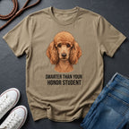Khaki Comfort Colors t-shirt with a dog illustration and text on a dark surface with shoes and jeans.