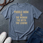 Blue Comfort Colors t-shirt with 'Poodle Mom: The Woman, The Myth, The Legend' text on a dark surface with shoes and jeans.