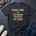 Black Comfort Colors t-shirt with 'Poodle Mom: The Woman, The Myth, The Legend' text on a dark surface with shoes and jeans.