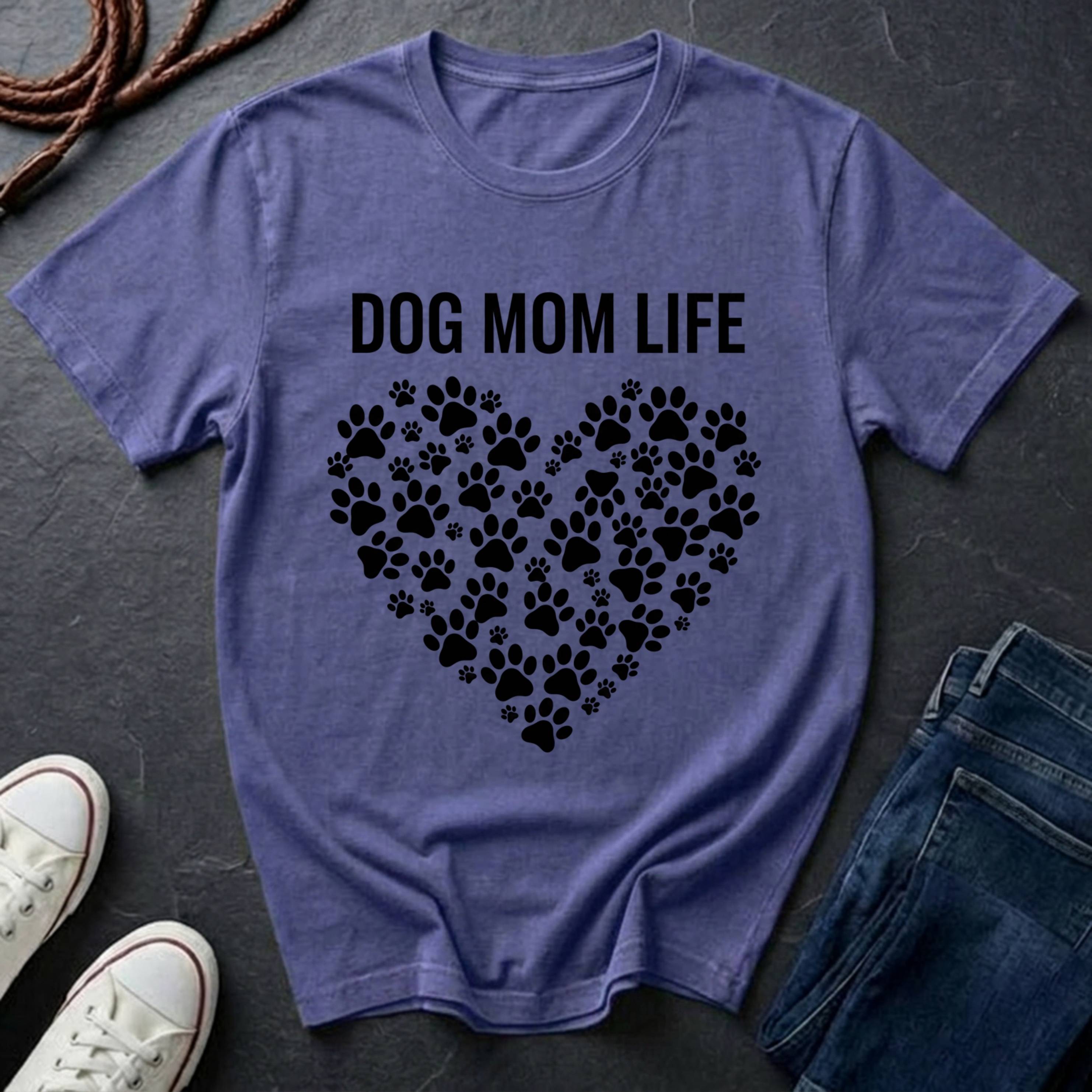 Purple Comfort Colors t-shirt with 'DOG MOM LIFE' text and paw prints on a dark surface with shoes and jeans.