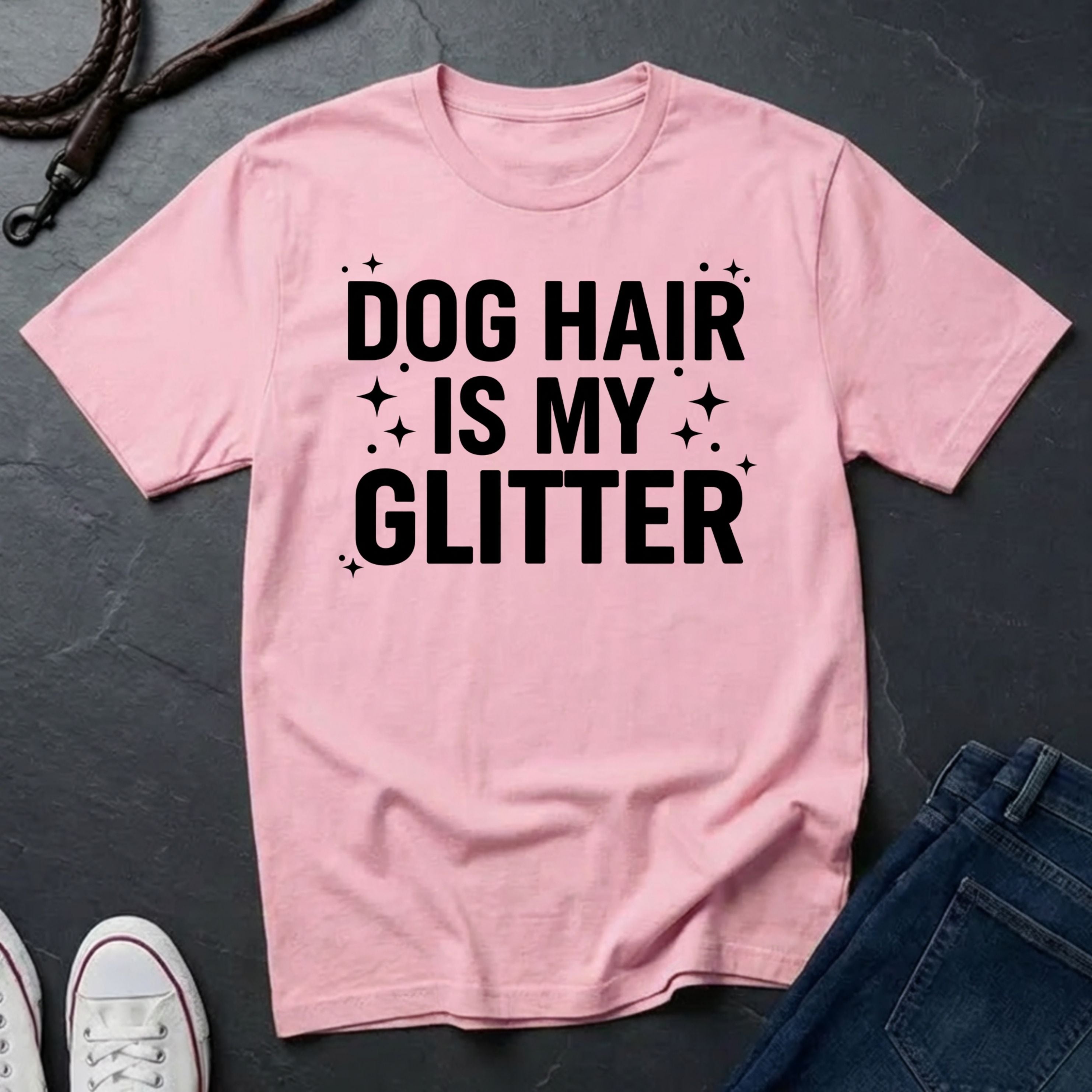 Pink Comfort Colors t-shirt with 'Dog Hair is My Glitter' text on a dark surface with jeans and shoes.