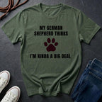 Green Comfort Colors t-shirt with text and paw print graphic on a dark surface with shoes and jeans.