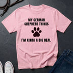 Pink Comfort Colors t-shirt with text and paw print design on a dark surface with jeans and shoes.