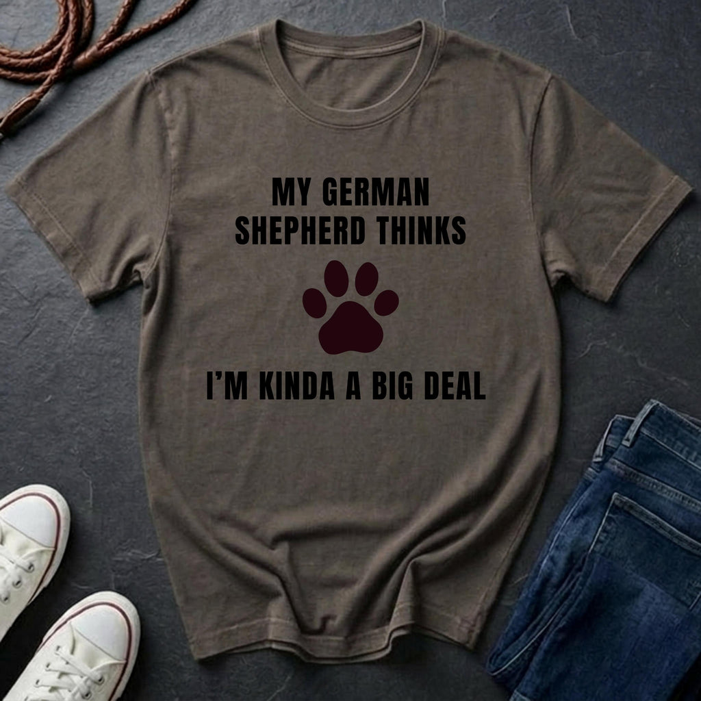 Brown Comfort Colors t-shirt with text and paw print on a dark surface with shoes and jeans.