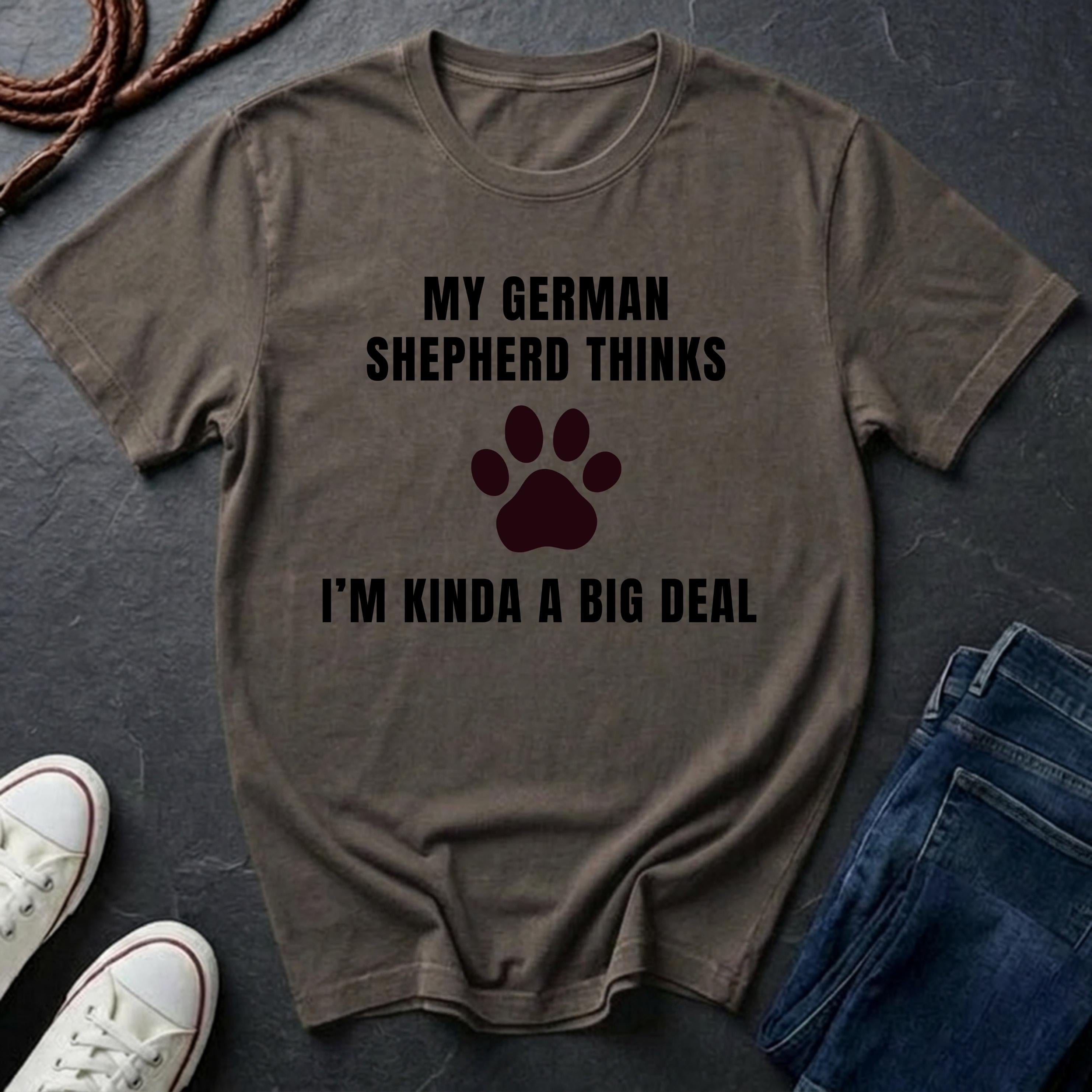 Brown Comfort Colors t-shirt with text and paw print on a dark surface with shoes and jeans.