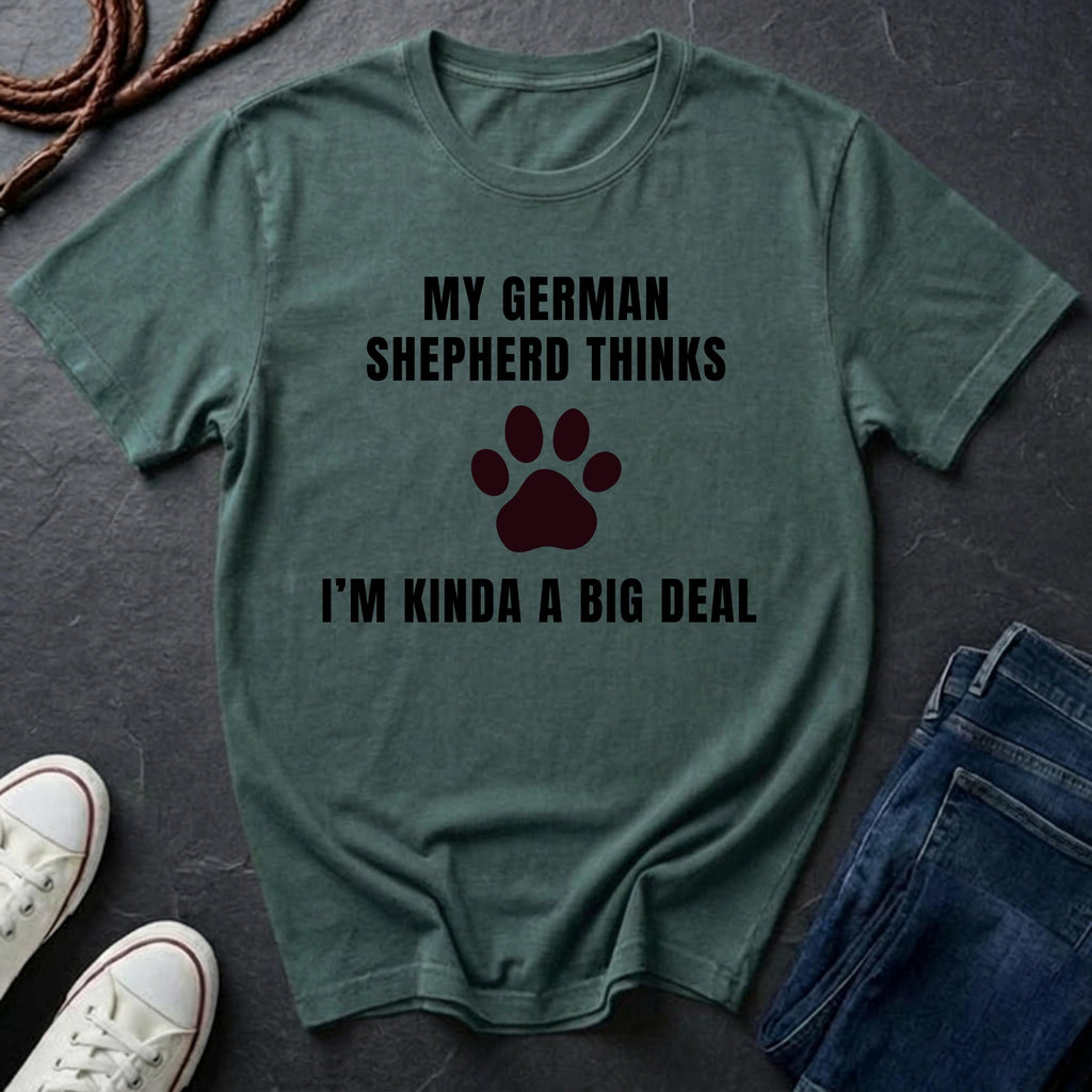 Green Comfort Colors t-shirt with text and paw print graphic on a dark surface with shoes and jeans.