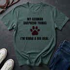 Green Comfort Colors t-shirt with text and paw print graphic on a dark surface with shoes and jeans.